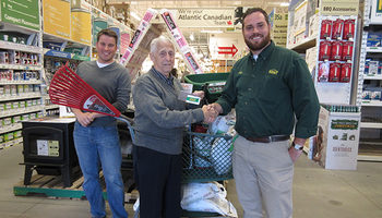 The winner of the Russell Lake Takes Root raffle prize receives his winnings at Kent Building Supplies Russell Lake