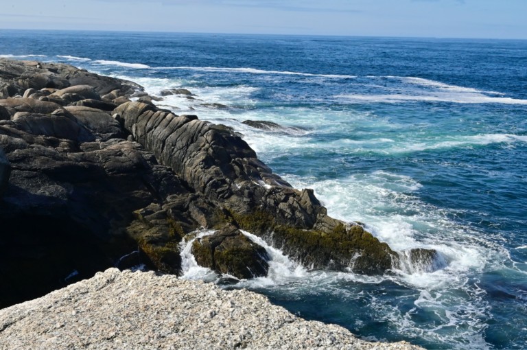 Waves hitting rocks on a shoreline. Page: BP Equinor Nova Scotia.