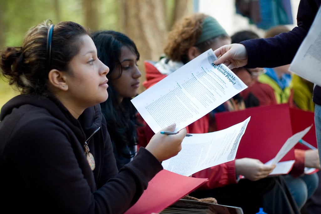 Youth members receiving informative paper handouts