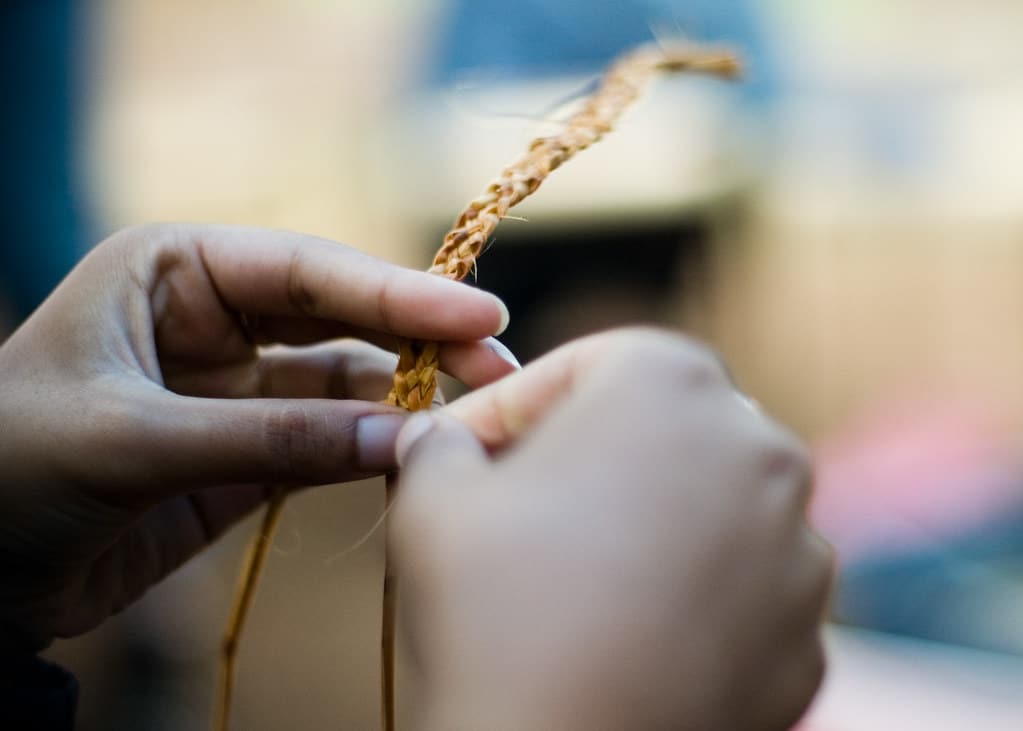 Close up of hands braiding grass
